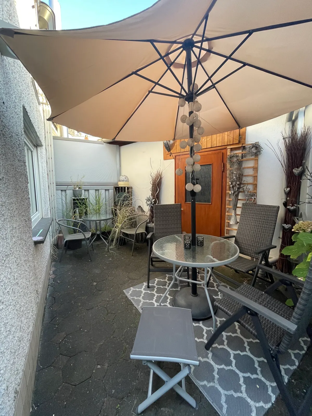 Sitzplatz mit Sonnenschirm im ruhigen Innenhof